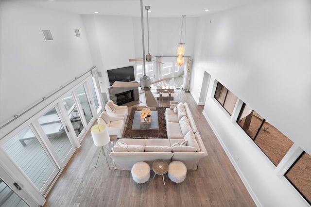 living room with a towering ceiling and light hardwood / wood-style flooring