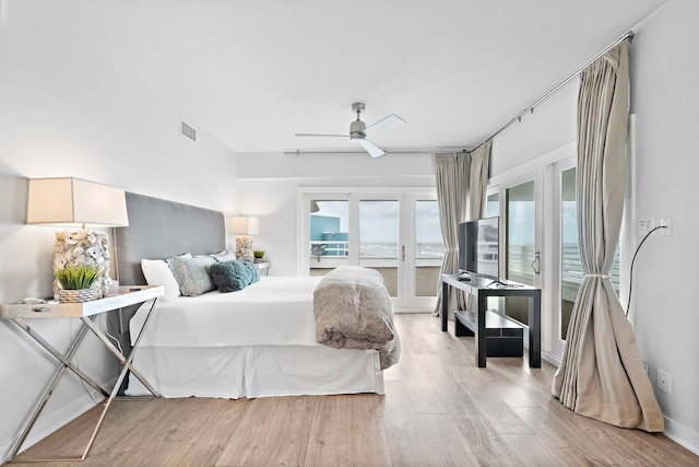 bedroom with ceiling fan, light hardwood / wood-style floors, access to exterior, and french doors