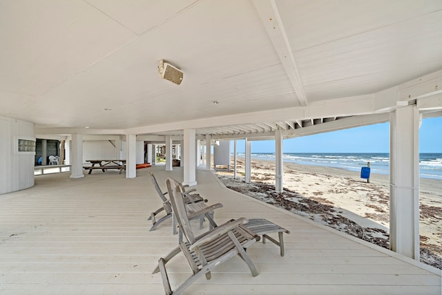 deck featuring a view of the beach and a water view