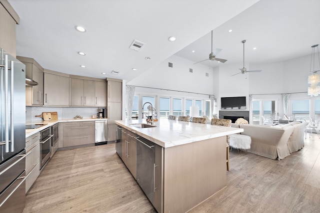 kitchen featuring a large island, a towering ceiling, sink, and a wealth of natural light