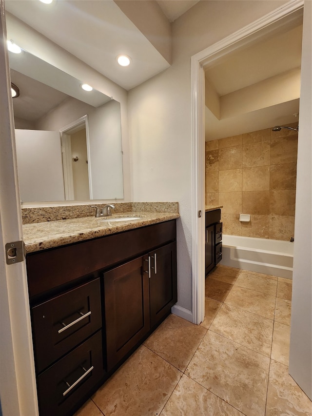 bathroom with vanity, tiled shower / bath combo, and tile patterned flooring