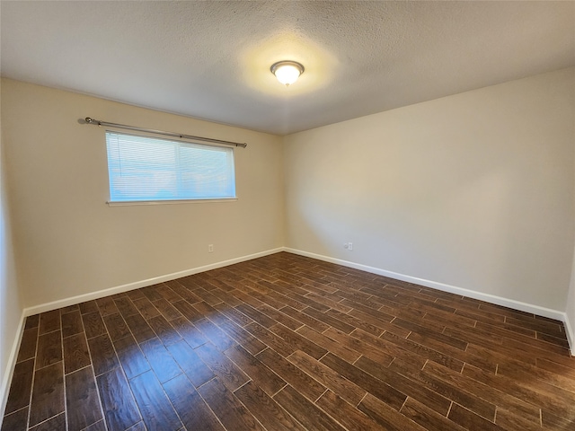 unfurnished room with a textured ceiling and dark hardwood / wood-style flooring