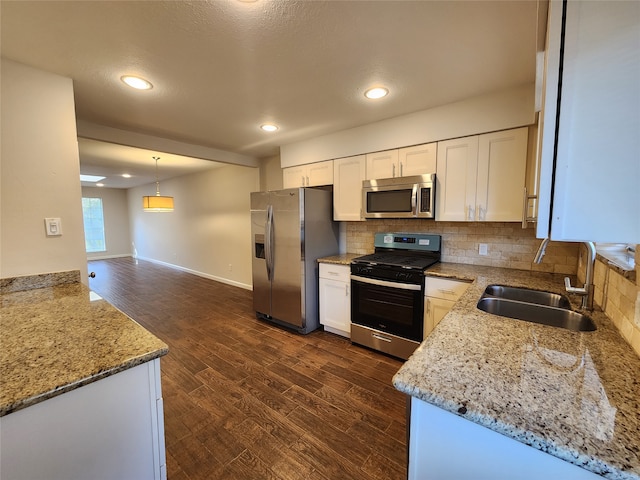 kitchen featuring white cabinets, stainless steel appliances, sink, and decorative light fixtures