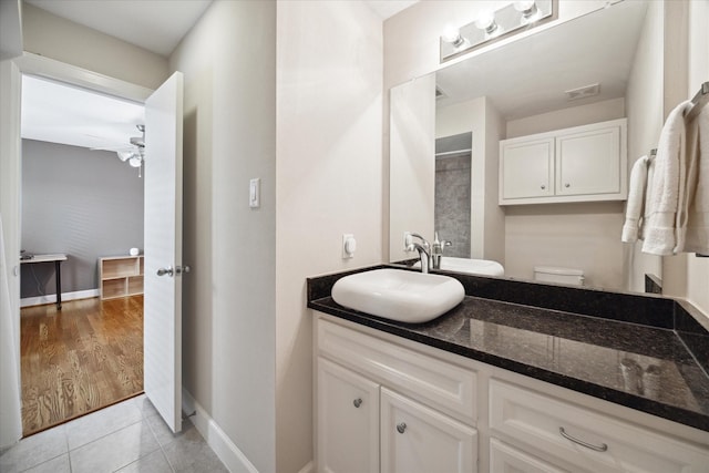 bathroom featuring vanity, tile patterned floors, ceiling fan, and toilet