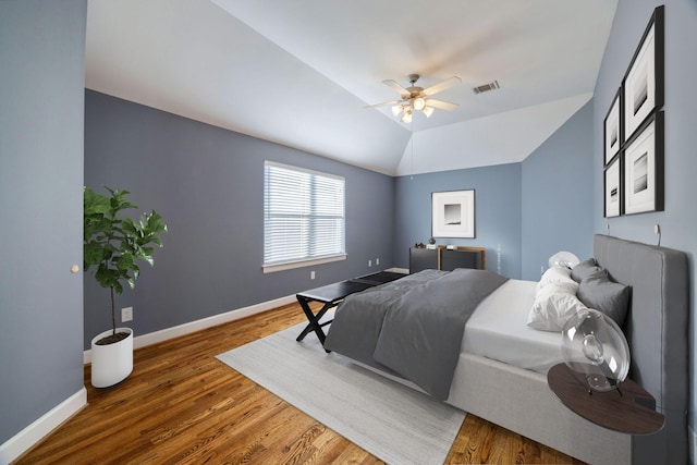 bedroom featuring dark wood-type flooring, vaulted ceiling, and ceiling fan