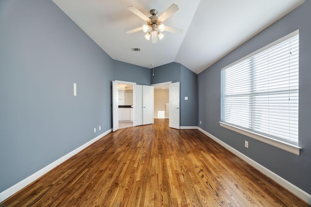 unfurnished bedroom featuring hardwood / wood-style flooring, lofted ceiling, ceiling fan, and multiple windows