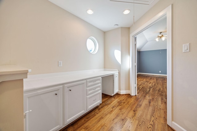 corridor featuring lofted ceiling and light hardwood / wood-style flooring