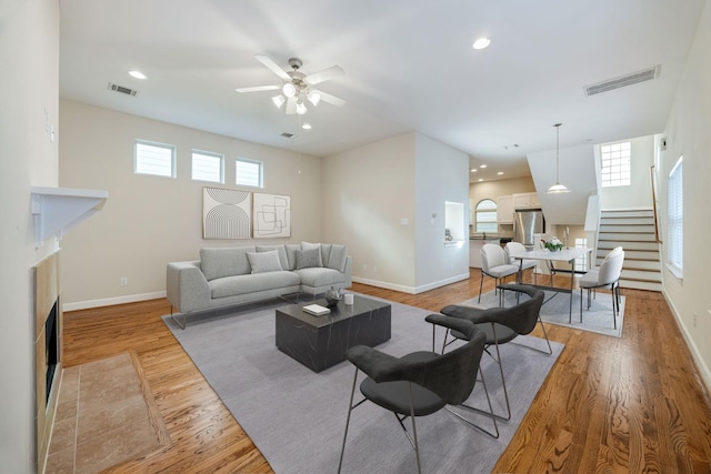 living room featuring ceiling fan and light wood-type flooring