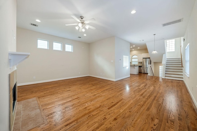 unfurnished living room with ceiling fan and light hardwood / wood-style floors