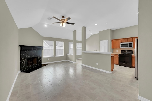 unfurnished living room with lofted ceiling, a high end fireplace, light tile patterned flooring, and ceiling fan