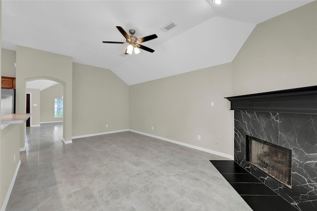 unfurnished living room featuring ceiling fan, a premium fireplace, and vaulted ceiling