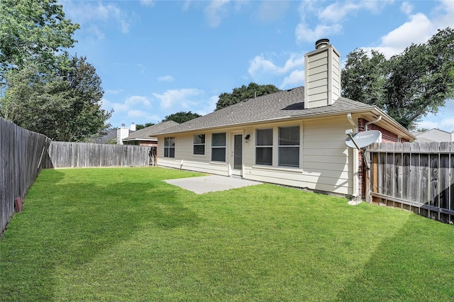 rear view of house with a yard and a patio