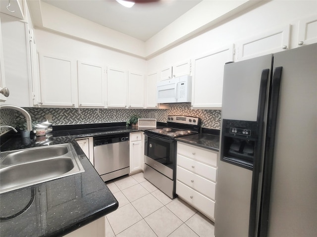 kitchen featuring tasteful backsplash, stainless steel appliances, sink, light tile patterned floors, and white cabinets