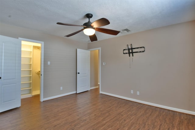 809 Pecan St, Brenham, TX 77833 - unfurnished bedroom with a walk in closet, wood finished floors, baseboards, and a closet