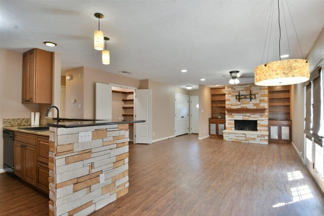 809 Pecan St, Brenham, TX 77833 - kitchen with a sink, a ceiling fan, baseboards, a fireplace, and dark wood-style flooring