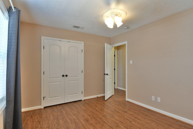 809 Pecan St, Brenham, TX 77833 - unfurnished bedroom with wood finished floors, baseboards, and a closet