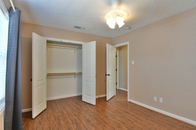 unfurnished bedroom with hardwood / wood-style floors and a closet