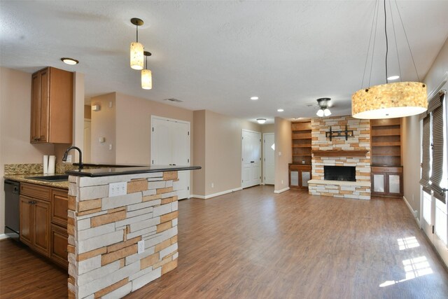809 Pecan St, Brenham, TX 77833 - kitchen featuring a sink, baseboards, a stone fireplace, dishwasher, and ceiling fan