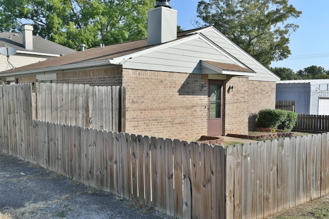 809 Pecan St, Brenham, TX 77833 - view of side of home with brick siding, a chimney, and fence