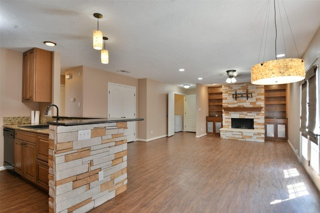 809 Pecan St, Brenham, TX 77833 - kitchen with a sink, a stone fireplace, dishwasher, ceiling fan, and wood finished floors