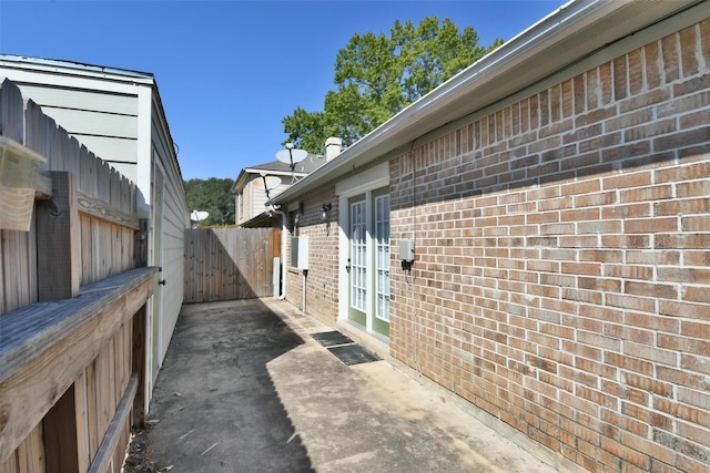 809 Pecan St, Brenham, TX 77833 - view of side of property featuring brick siding, french doors, fence, and a patio area