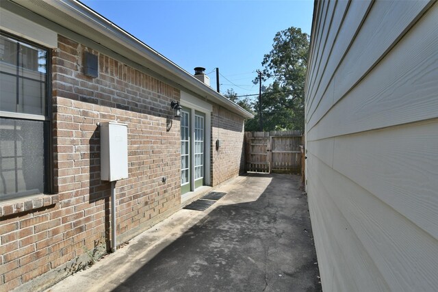 809 Pecan St, Brenham, TX 77833 - view of side of property with brick siding, fence, and a patio