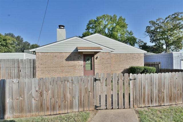 809 Pecan St, Brenham, TX 77833 - view of side of home featuring brick siding, fence, and a chimney