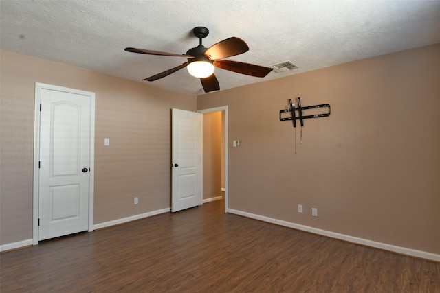 809 Pecan St, Brenham, TX 77833 - unfurnished bedroom with dark wood-type flooring, baseboards, a textured ceiling, and a ceiling fan