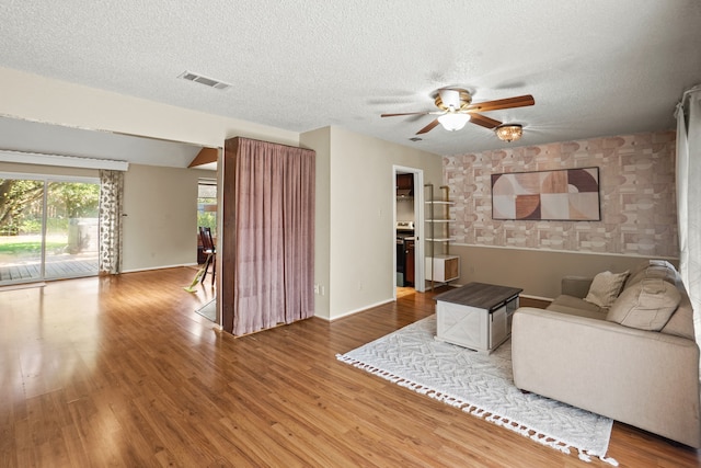 living room featuring hardwood / wood-style floors, a textured ceiling, and ceiling fan