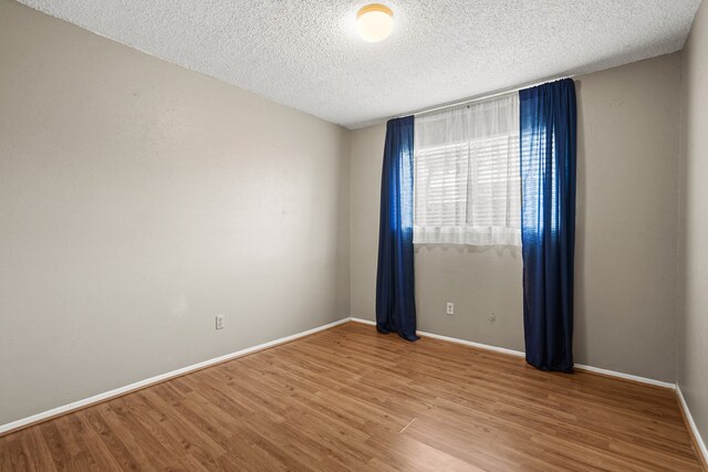 spare room with hardwood / wood-style floors and a textured ceiling