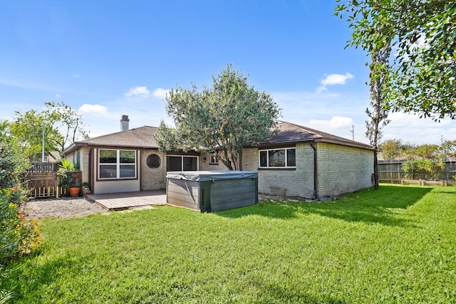 rear view of property with a wooden deck and a lawn