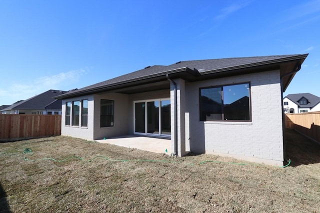 rear view of property featuring a lawn and a patio