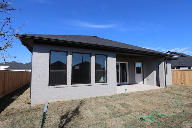 back of property with a yard and a patio