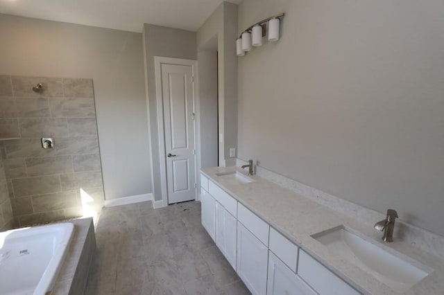 bathroom featuring vanity and tiled tub