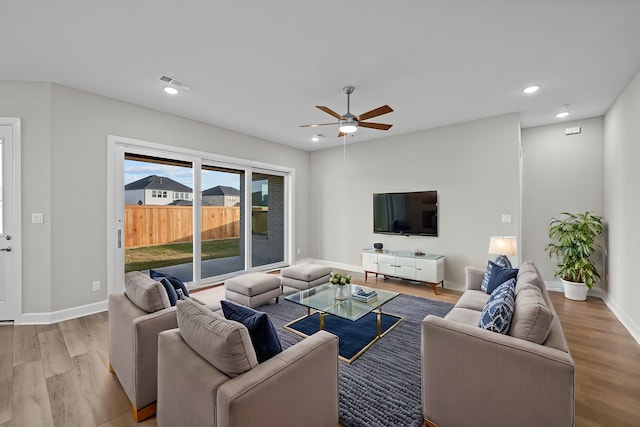 living room featuring light hardwood / wood-style floors and ceiling fan