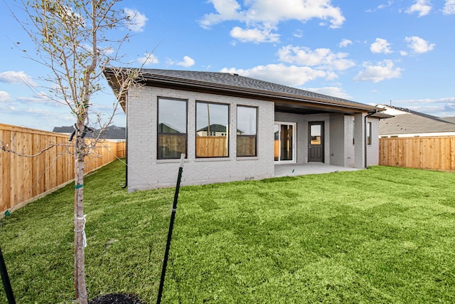 back of house with a lawn and a patio area