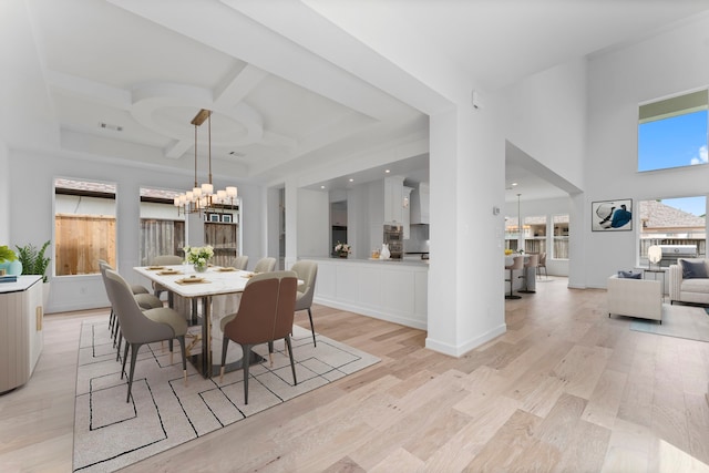 dining area featuring light hardwood / wood-style floors, coffered ceiling, beam ceiling, and an inviting chandelier