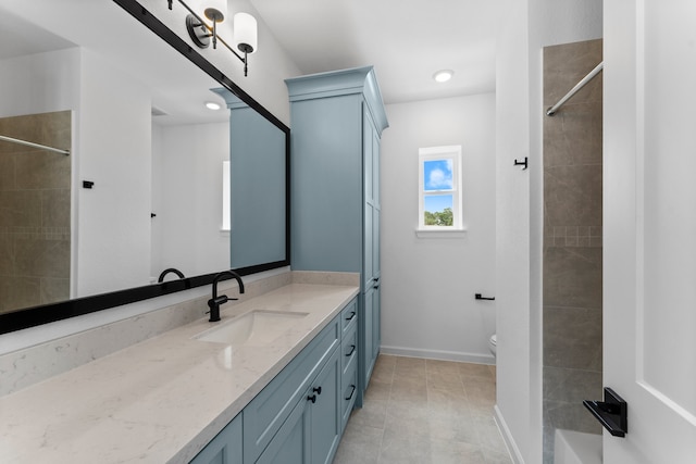 bathroom with vanity, toilet, tile patterned floors, and tiled shower