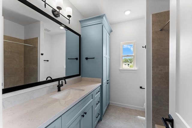 bathroom with vanity, a tile shower, and tile patterned floors