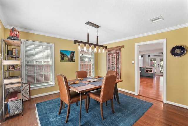 dining space featuring crown molding and dark hardwood / wood-style floors