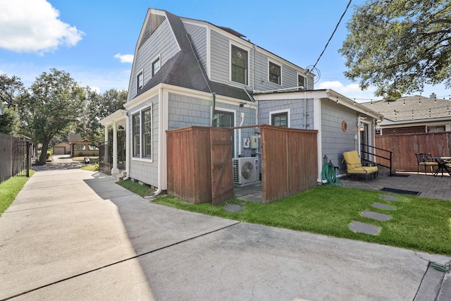 back of house with a yard and ac unit