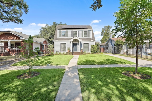 view of front of house featuring solar panels and a front yard