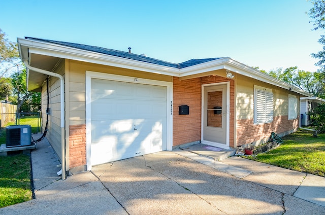 single story home with central AC unit and a garage