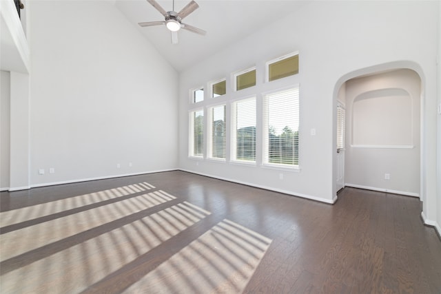 empty room with ceiling fan, high vaulted ceiling, and dark hardwood / wood-style flooring