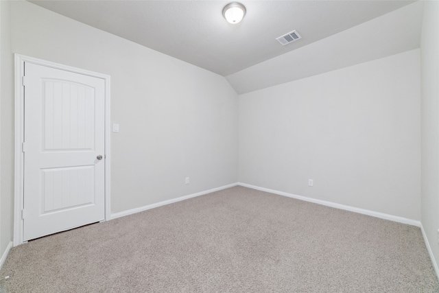 spare room featuring lofted ceiling and carpet floors