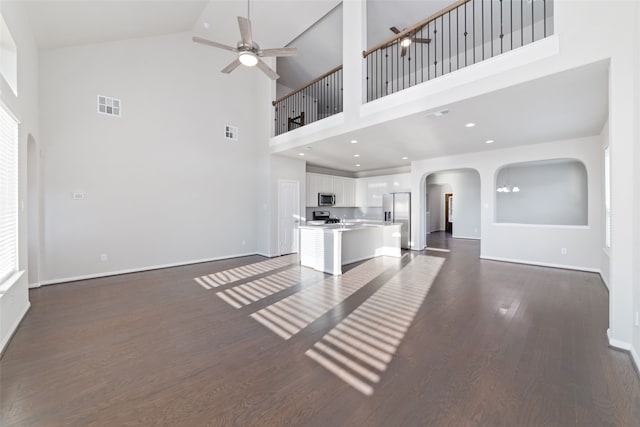 unfurnished living room with dark hardwood / wood-style floors and high vaulted ceiling