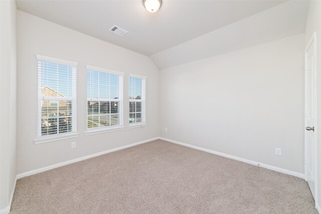 spare room featuring vaulted ceiling and carpet floors