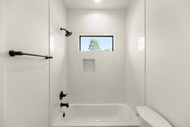 bathroom featuring toilet and tiled shower / bath combo