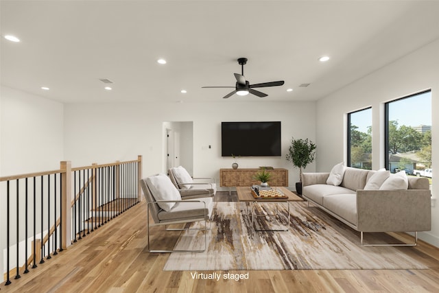 living room with light hardwood / wood-style flooring and ceiling fan