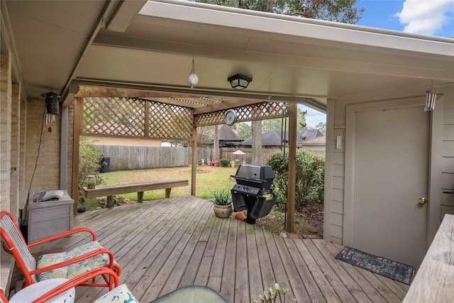 wooden terrace featuring area for grilling and a yard